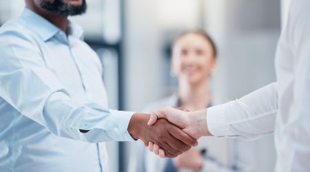 Shot of two unrecognizable businesspeople shaking hands in an office at work.